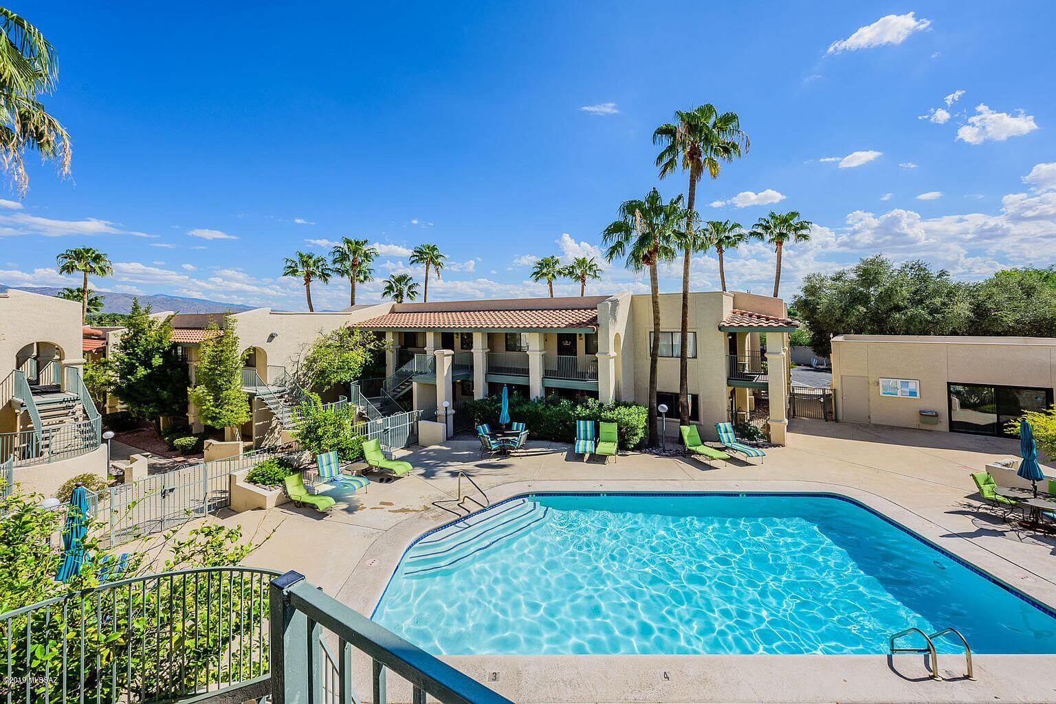 Desert resort pool with palm trees and mountains